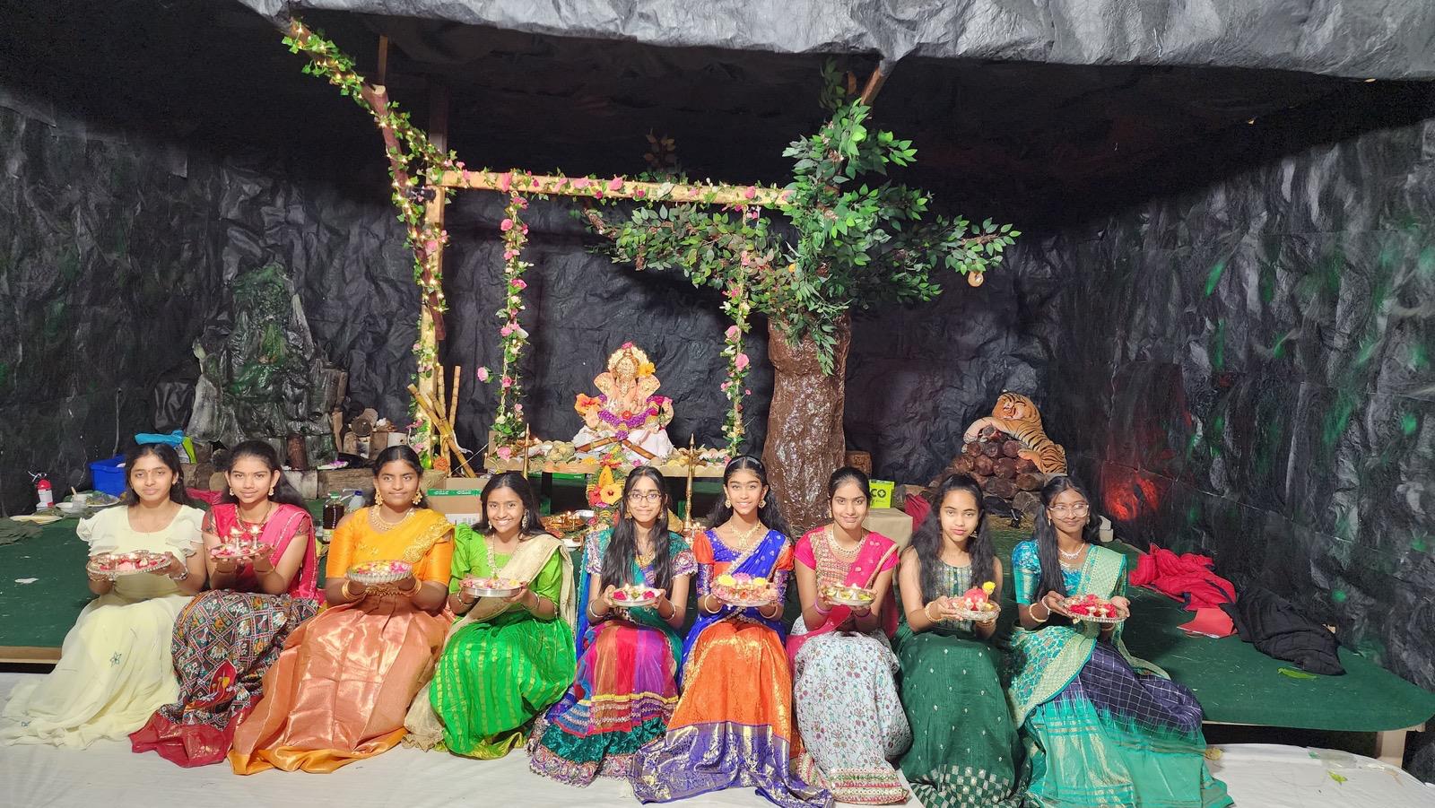 Young girls in colourful sarees holding traditional offerings at the mandap, 2023