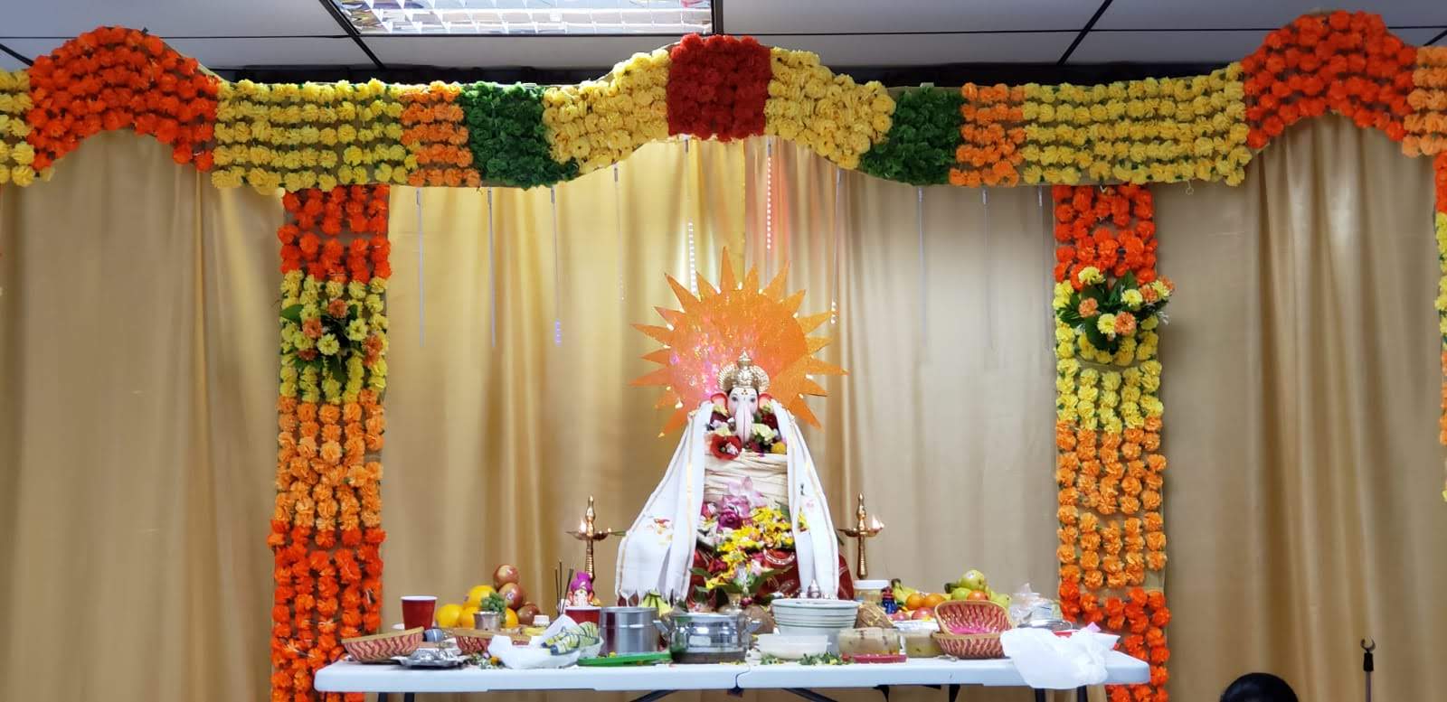 Ganesh mandap decorated with orange, yellow, and green marigold garlands, 2019