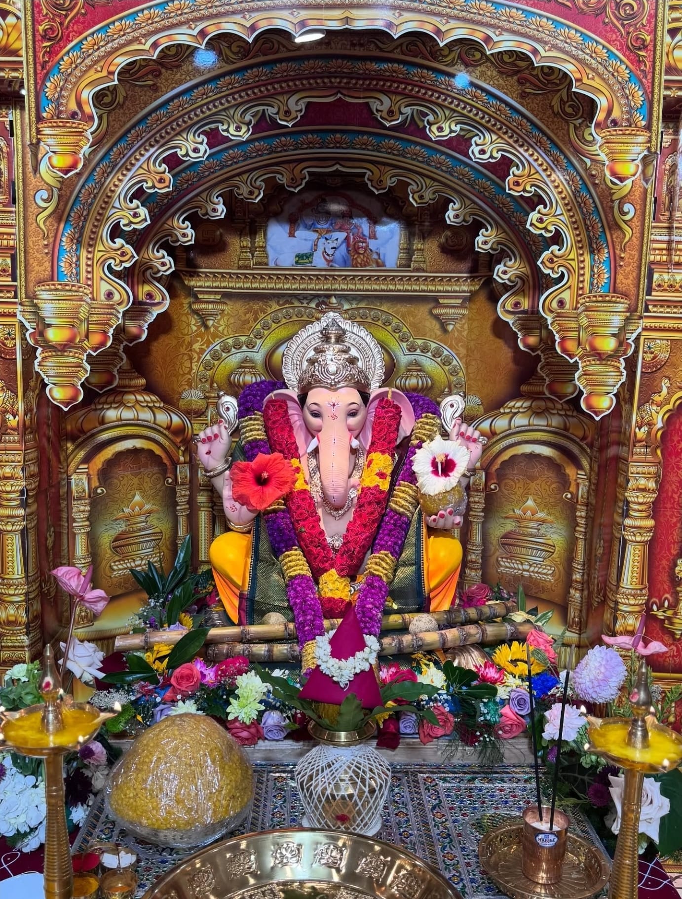 Close-up of Lord Ganesh adorned with red, purple, and white garlands, 2025