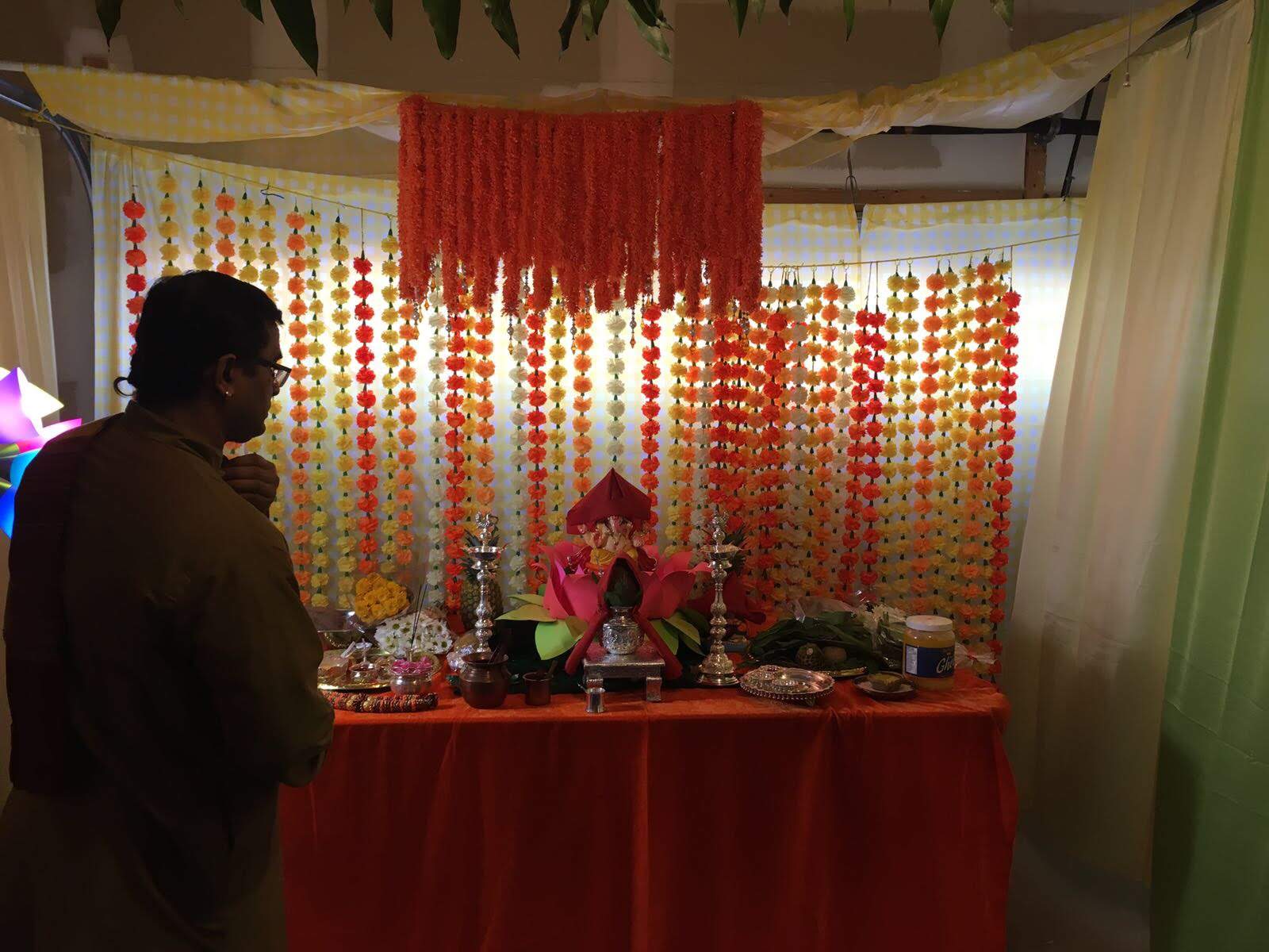 Priest performing pooja before the decorated Ganesh altar, 2017
