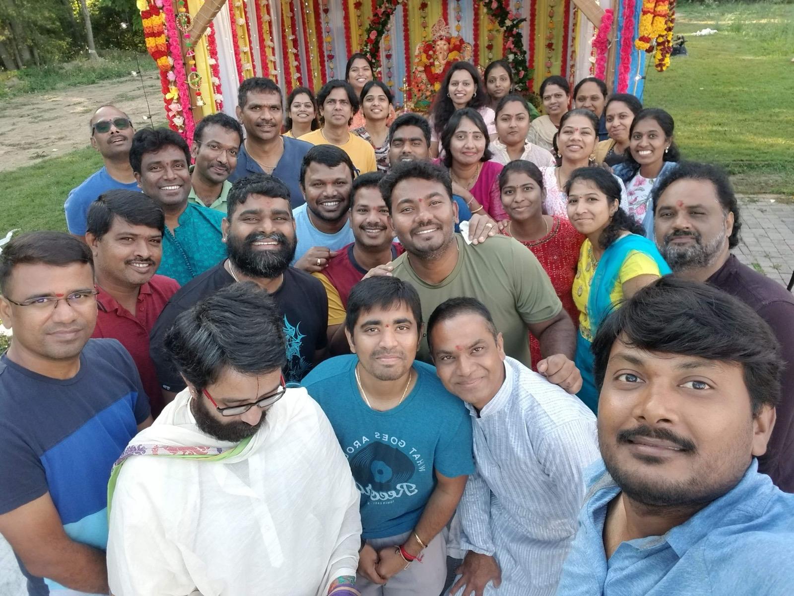 Large community group selfie in front of the colourful Ganesh mandap, 2022