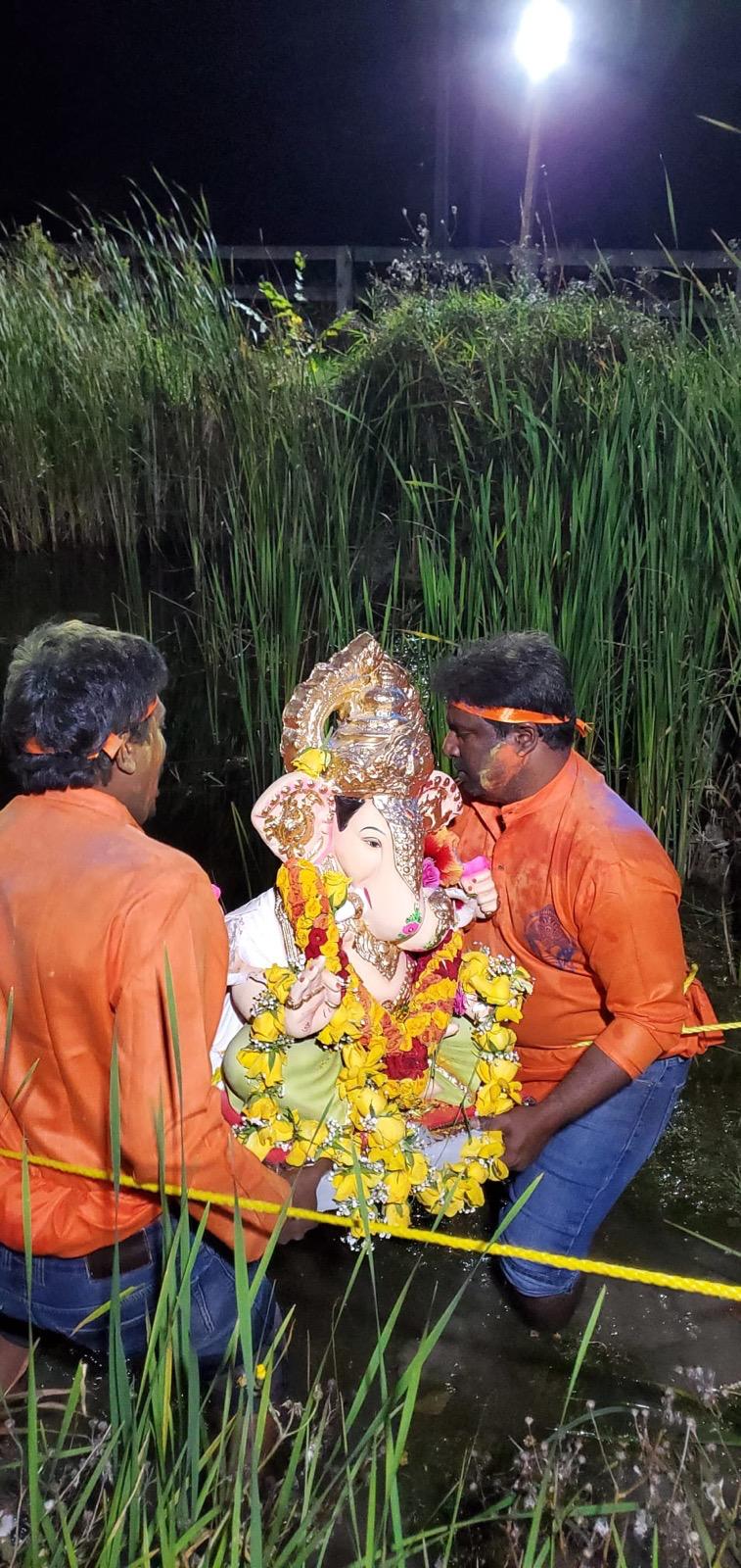 Community members carrying Lord Ganesha for nimarjan by the water, 2023